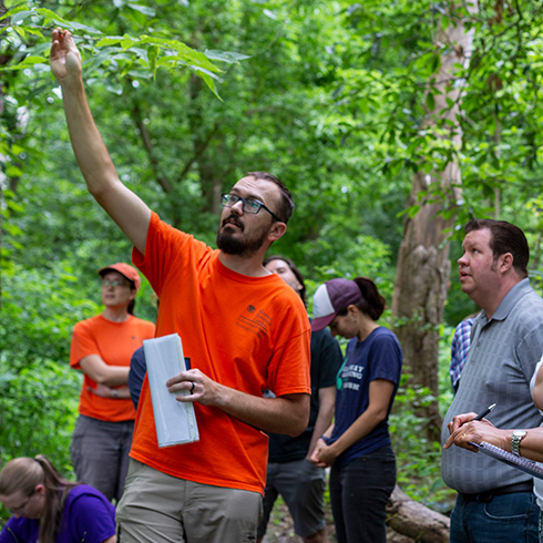 instructor addressing group in wooded setting
