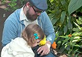Father and daughter in butterfly conservatory