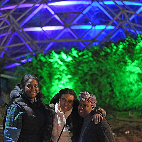Group posing in front of glowing green Climatron conservatory