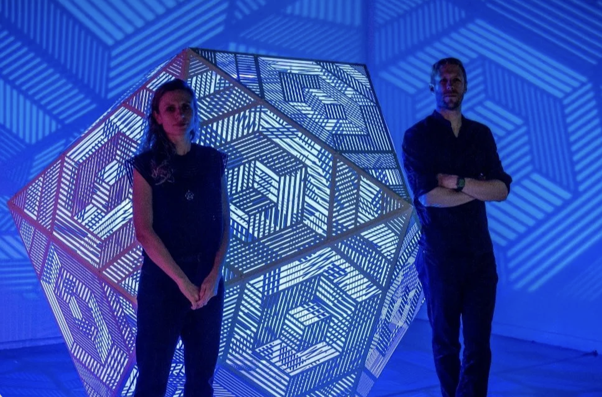woman and man with glowing blue geometric sculpture