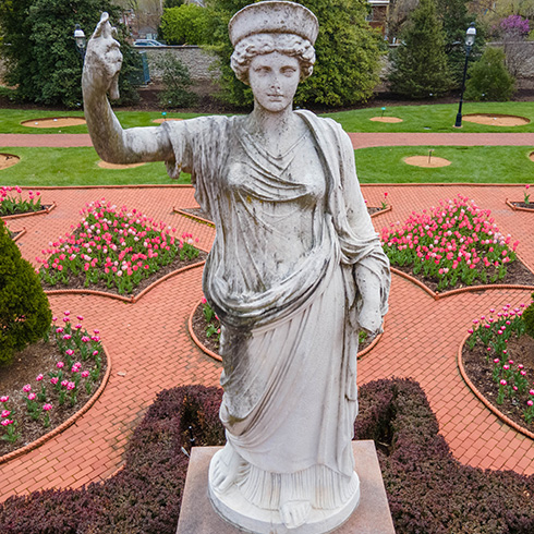 Statue of Juno surrounded by pink tulips