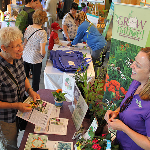 Visitor meeting green living expert at exhibitor table