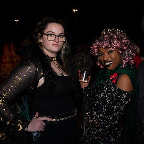 Young adults in costumes with drinks