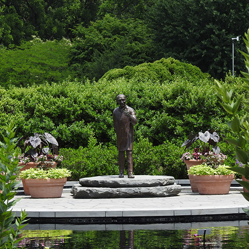 George Washington Carver statue surrounded by greenery and potted plants
