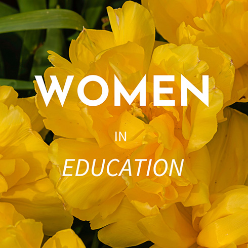 Women in Education written over a background of yellow blossoms