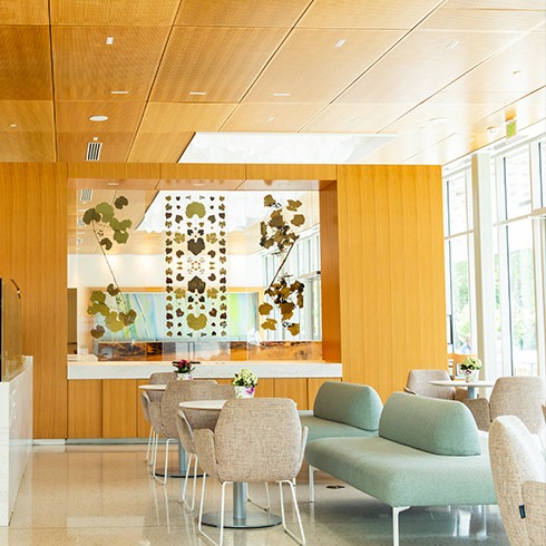 Restaurant interior with wood details, white tables, and light pastel furniture