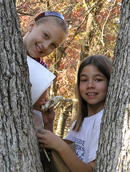 Two Habitat Helpers examining a tree