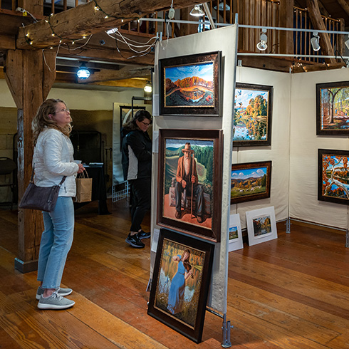 Adult viewing artwork inside rustic cabin
