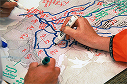 Hands drawing watersheds on map