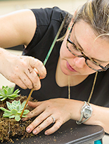 Class participant creating wreath from succulents