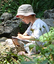 boy writing outdoors