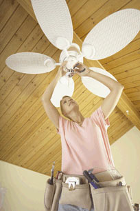 Homeowner installing a ceiling fan
