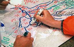 Hands drawing watersheds on map