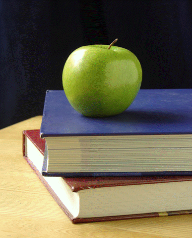 Green apple sitting on stack of two books